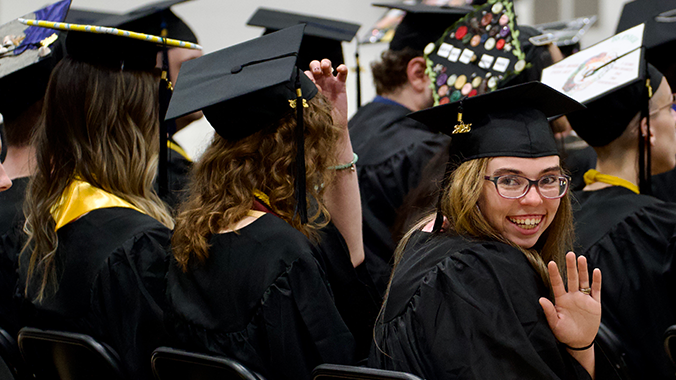 A photo of a graduate waving