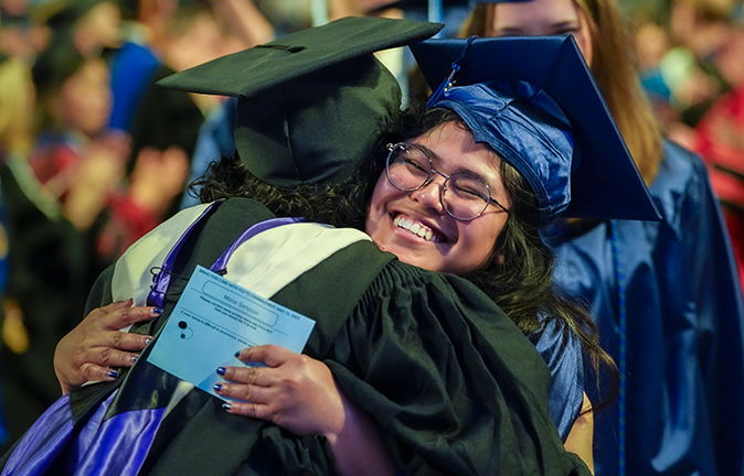 A photo of a student hugging her advisor