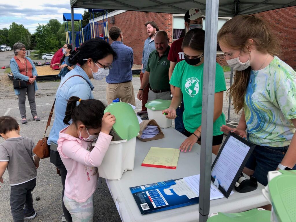 Child looking in a food recycling bin
