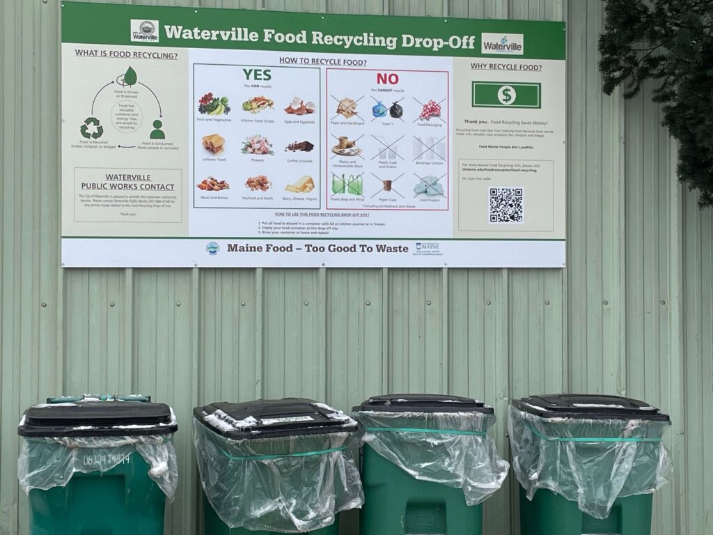 Image of the Waterville transfer station: features four recycling bins under a food recycling sign