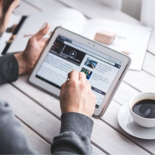image of a man browsing a news page on his iPad