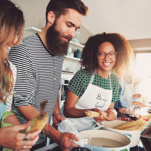picture of three people cooking and smiling at the camera