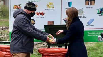 Image of two people demonstrating how to dispose of food waste at Portland city launch