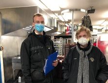 Photo of a man and woman in masks looking at the camera