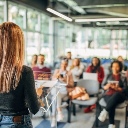 A person teaching a classroom of people