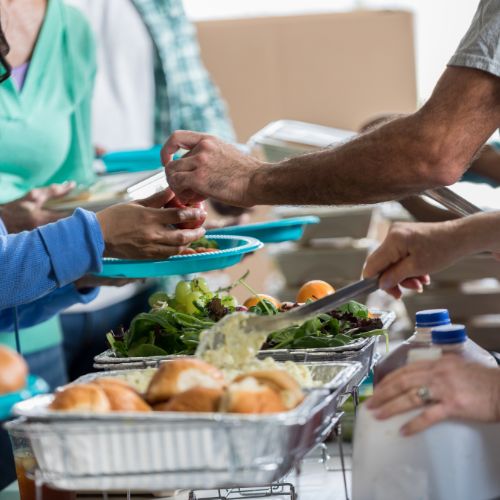 A person serving food to another person