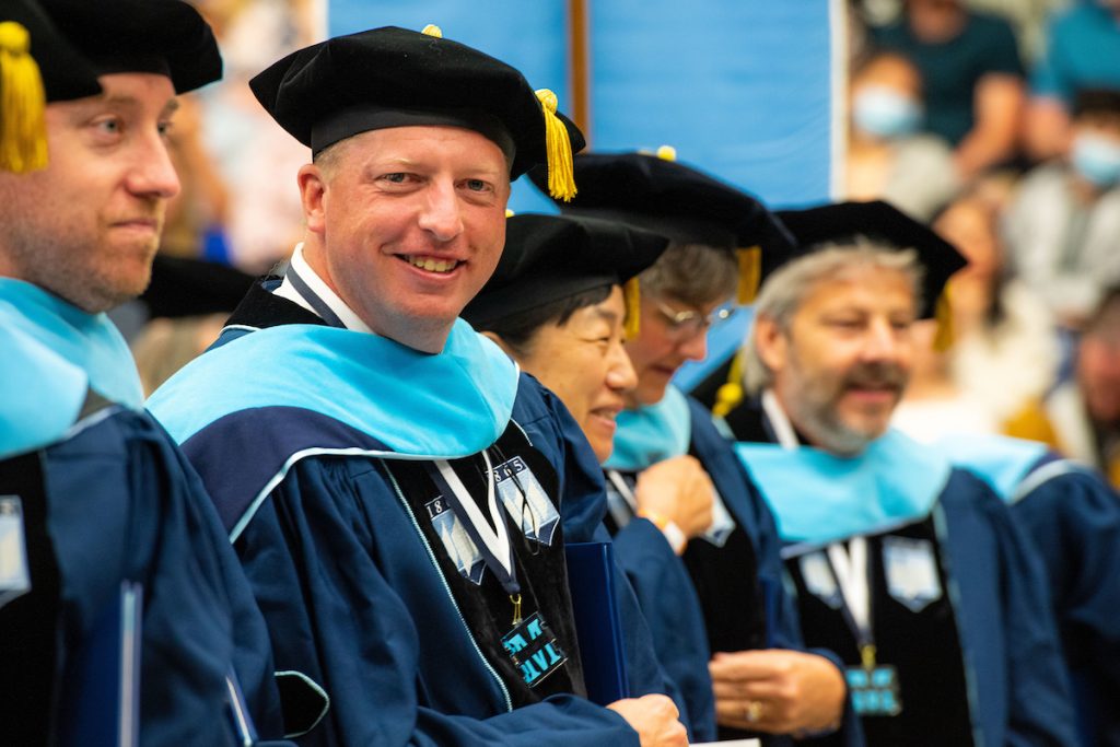 Image of doctoral students in regalia attending a commencement ceremony