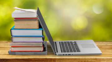 laptop and books on table outside