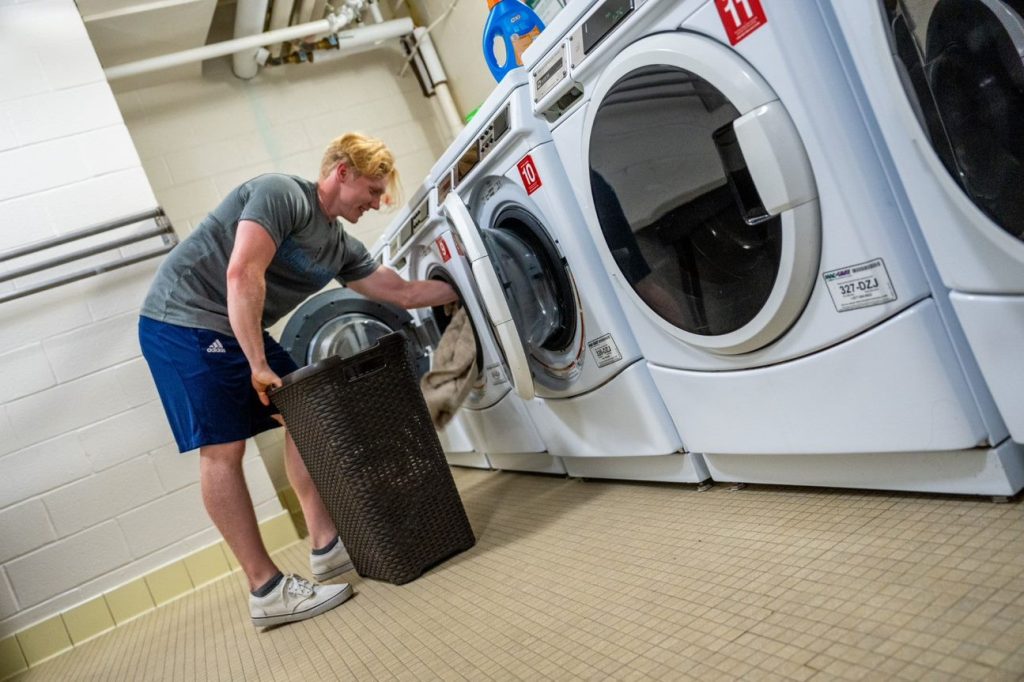 Student doing laundry in UMaine dorm
