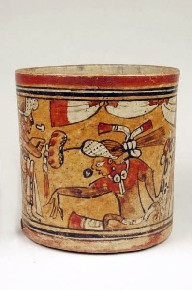 Vase with vertical sides. Orange slip under red, black, white, and brown on the exterior. The rim is encircled with a red, orange, black, white, black, orange, and black bands and the base has the bands in reverse order.  Between is a figure seated in the tailor position facing to the left. This figure has his right arm extended out in gesture to the standing figure. The seated figure wears a headdress with water lily extension and has either a pillow or bundle wrapped in jaguar skin at his back. The figure is seated underneath a draped ceremonial banner and is represented in conversation with speech glyphs. 
