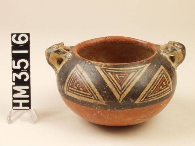 Miniature polychrome ceramic jar with frog effigy handles. Abstract designs on a dark band around the top half of the vessel with abstract claws in what may be geometric boa ovals or kennings for frog legs within boa ovals.