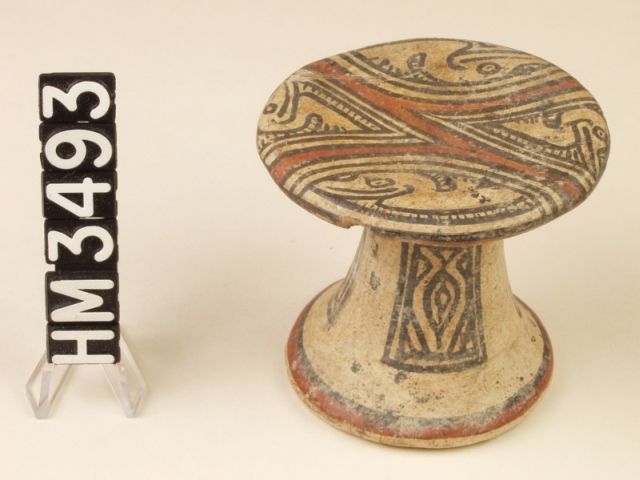 Miniature polychrome ceramic pedestal plate. Four long-billed birds resembling herons fill four spaces created by red bands that may be "Y" element variations. The entire design is encompassed by red lines, which may represent the boa body line. Two triangular spaces within the red bands may be variations on boa ovals, filled by the birds. The same birds appear in the hemispheres on either side of the boa body.