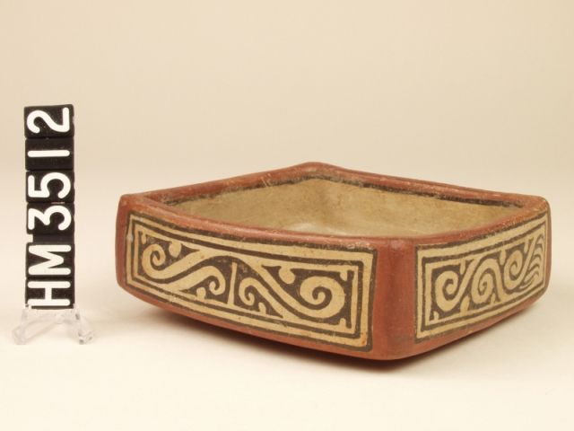 Polychrome square ceramic dish with vertical sides and curvilinear designs.