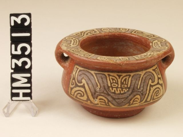 Miniature polychrome ceramic jar. Side panels depict a front-facing, toothy bat, body line and wings depicted in purple.