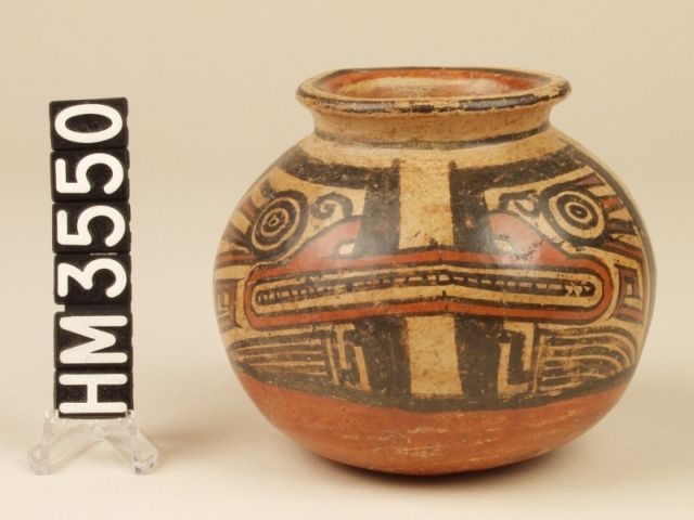 Miniature polychrome ceramic jar. Design of iguana-boa with characteristic toothed mouth, eye stripe, and clawed limbs integrates the dual hemispheres of this jar.