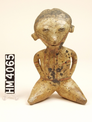 Ceramic figure in kneeling posture.