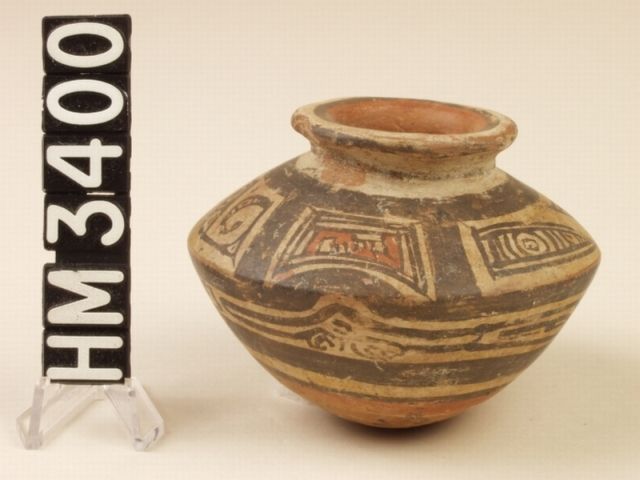 Miniature polychrome ceramic angled jar representing the body of a turtle. The head and fore limbs appear on the front side and the tail and hind limbs appear on the rear side. Panels on the left jar are marked with animal kennings and panels on the center jar contain serpent kennings.
