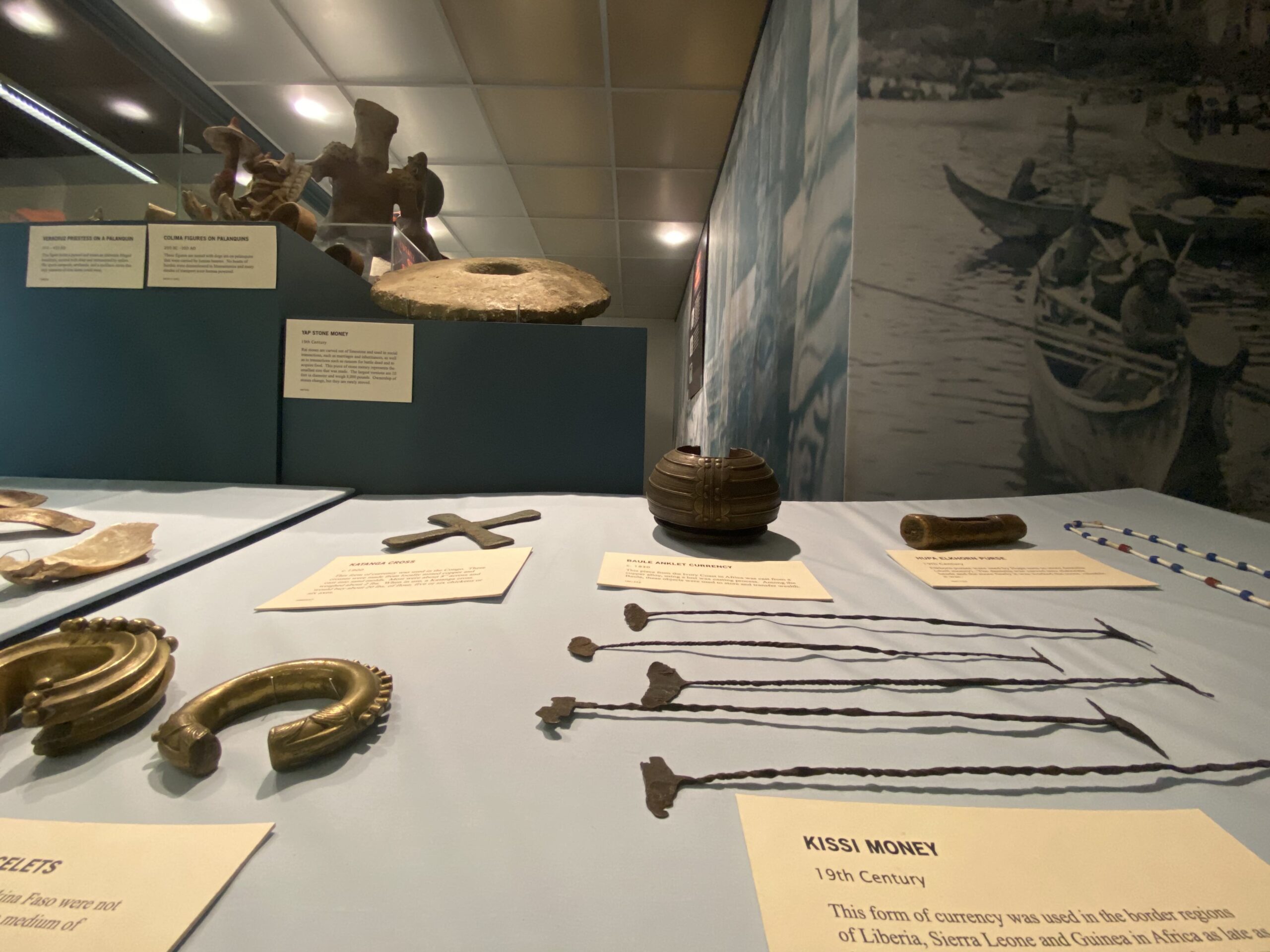 Museum exhibit featuring long, narrow pieces of metal with wide elements on each end.