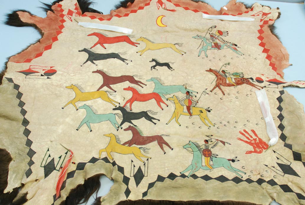 Image of buffalo skin with painted colorful horses.