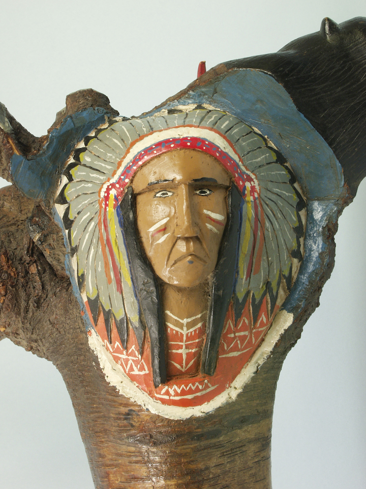 Image of a carved and painted face in the form of a plains native american male.