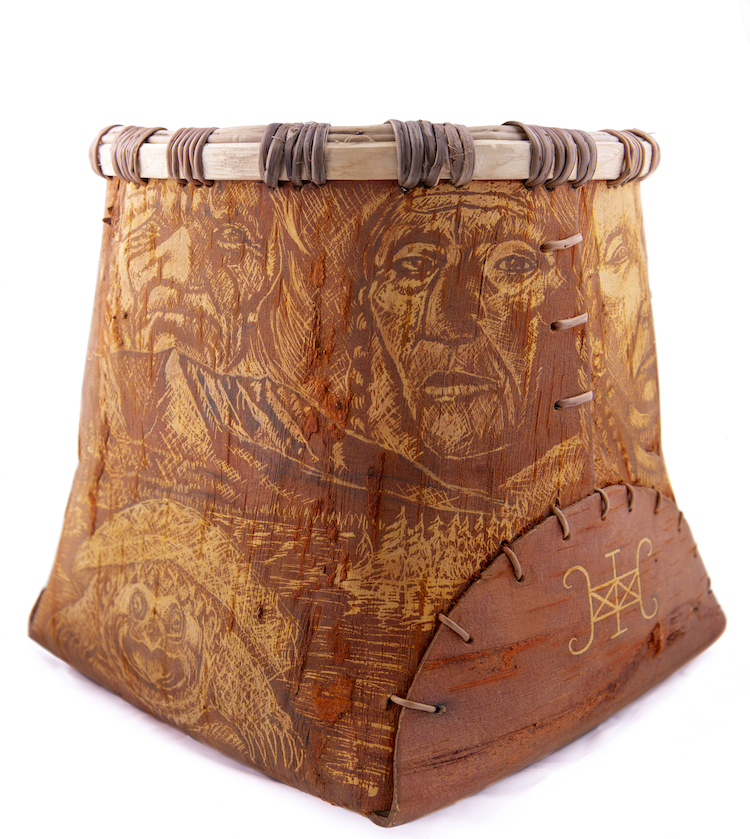 Image of a birchbark container with intricate images of faces and landscapes.