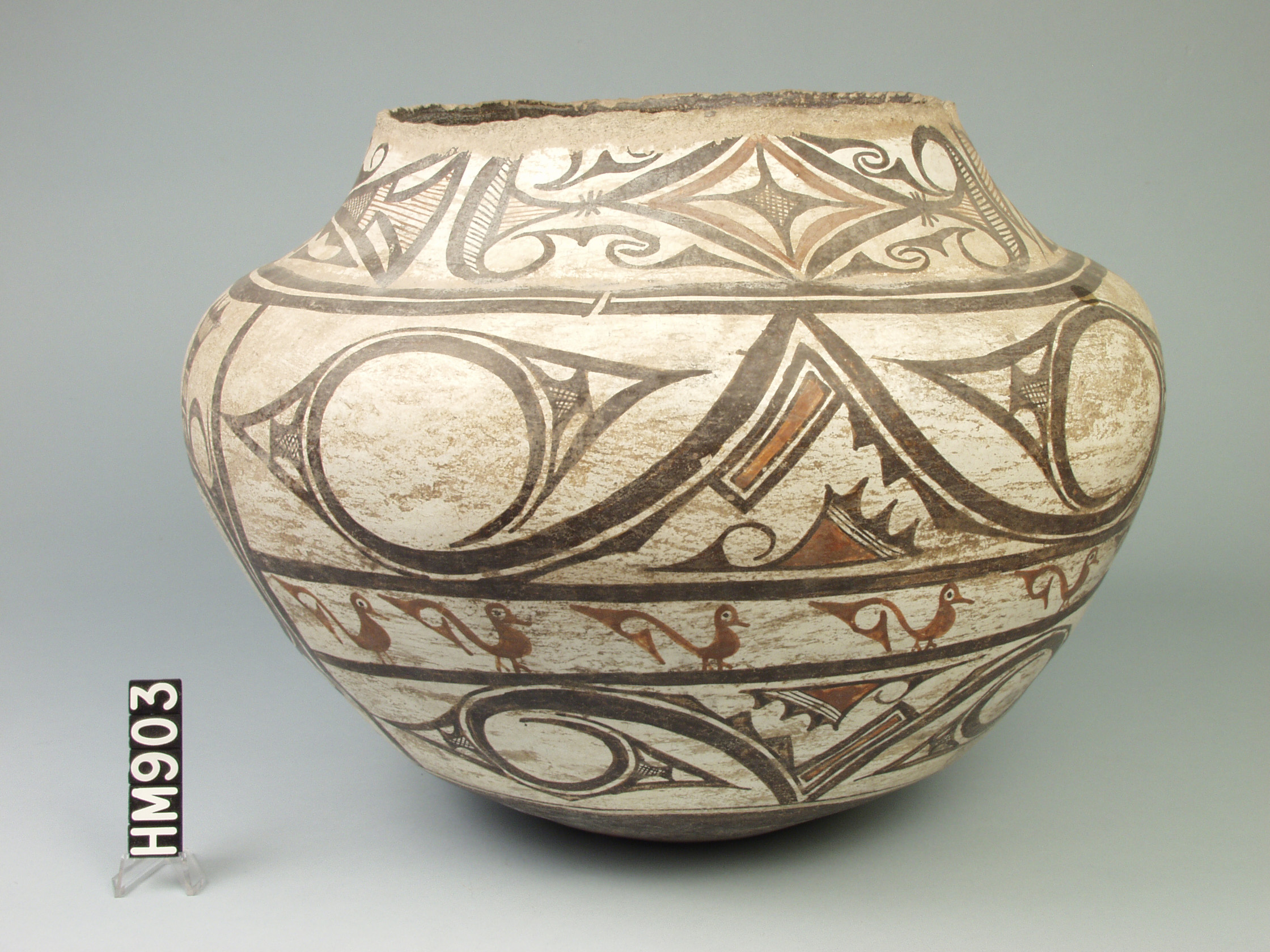 Image of a southwestern ceramic pot with red and black decorations on a white background.