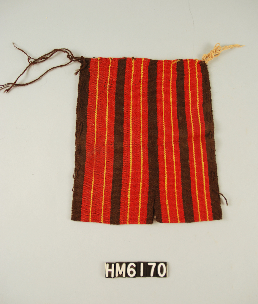 Image of a tiny poncho with red, black, and yellow stripes.
