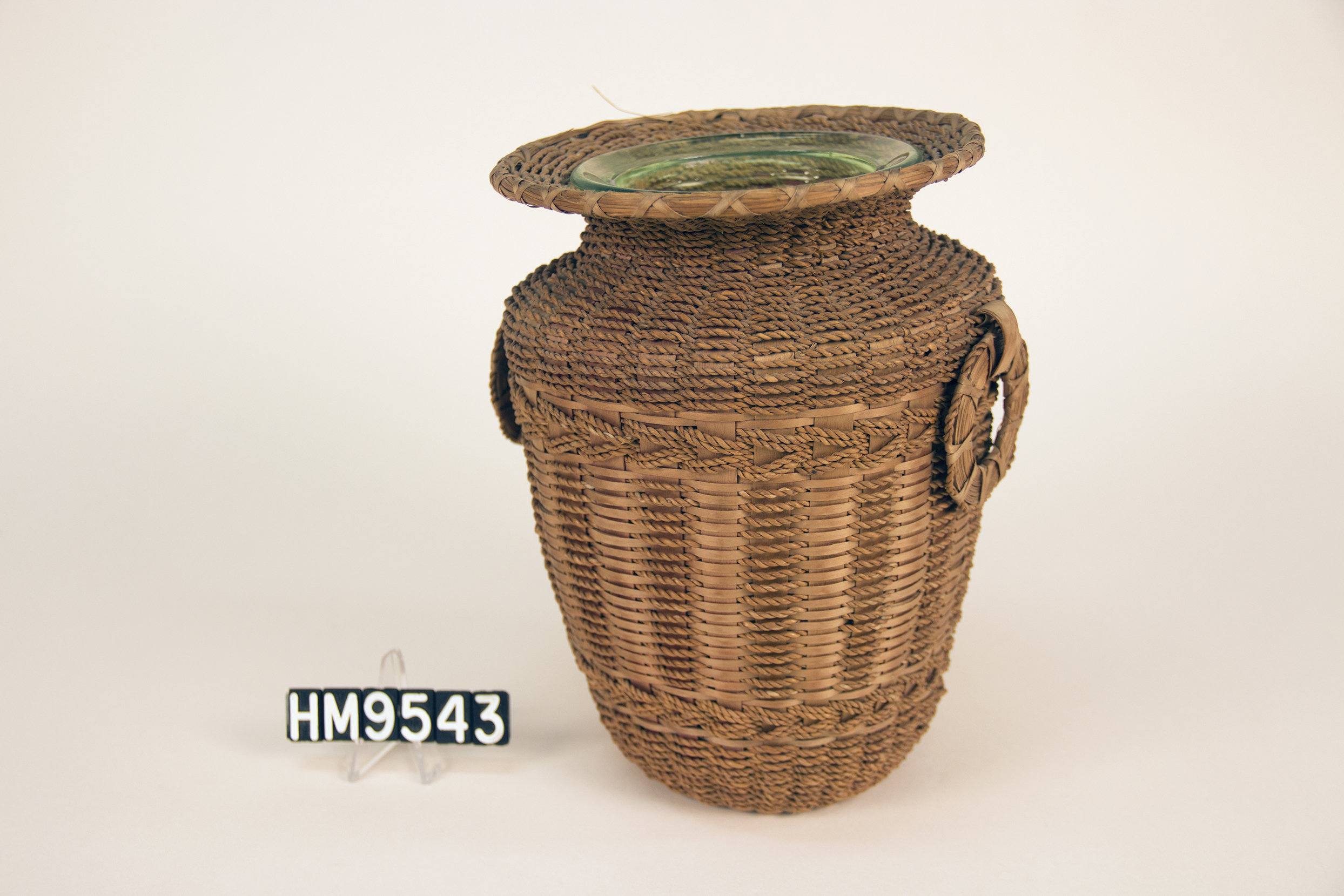 Basket woven over a vase with patterns formed from Hong Kong cord.