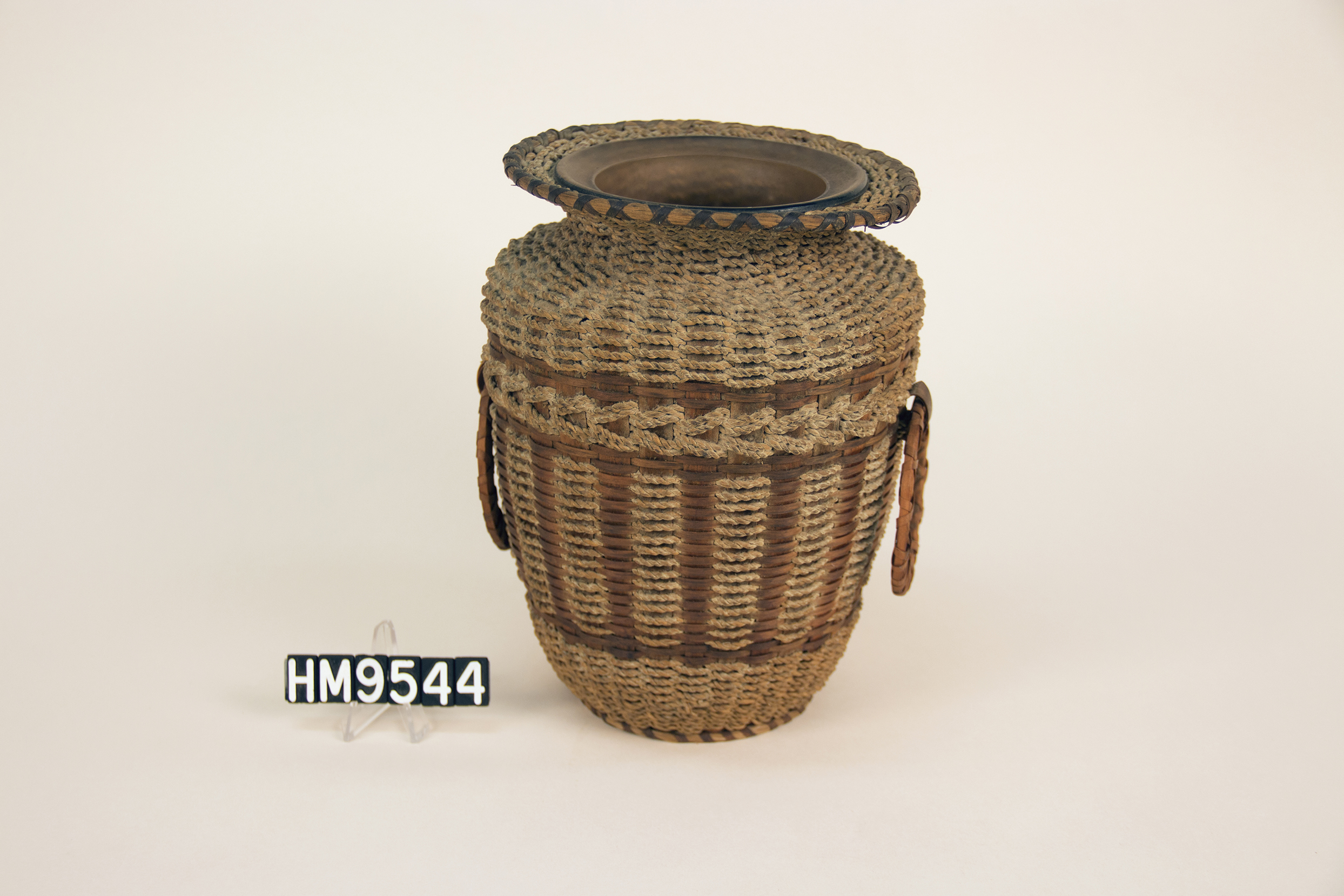 Basket woven over a vase with patterns formed from Hong Kong cord.