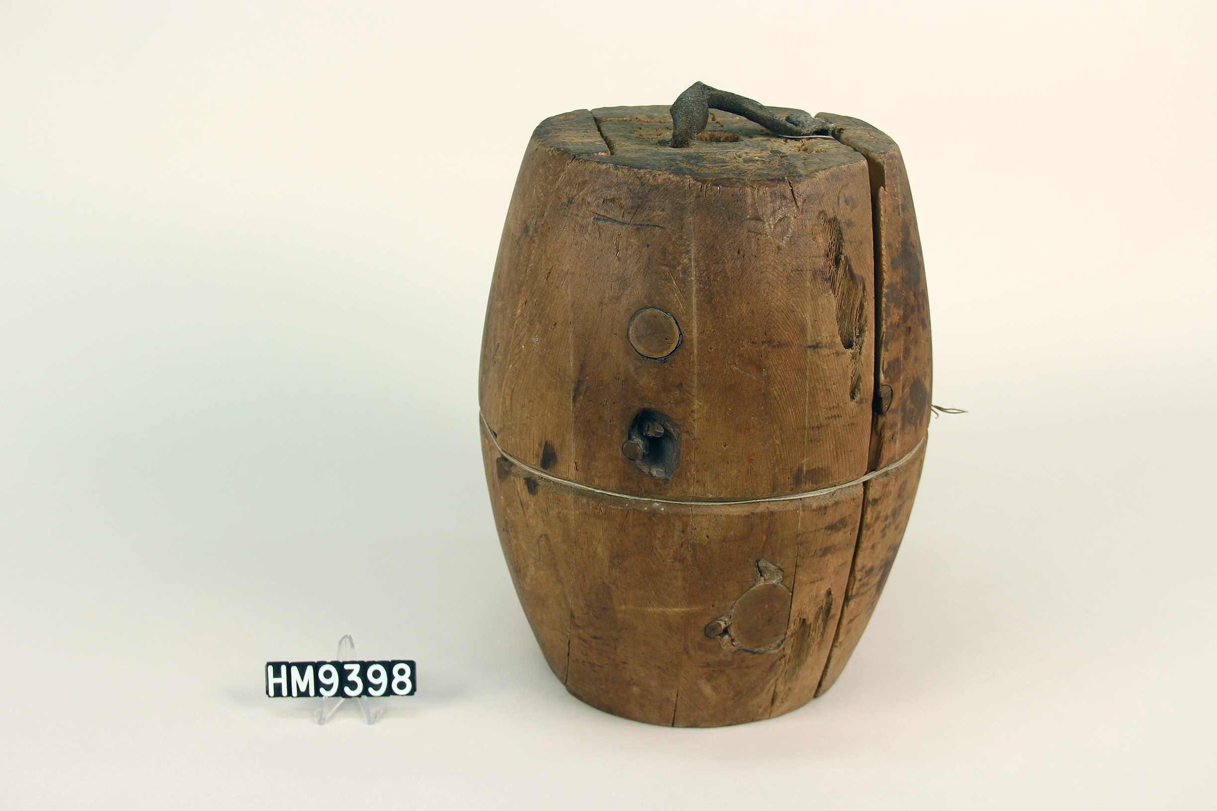 Image of basket block for shaped like a barrel and made of multiple pieces fitted together.