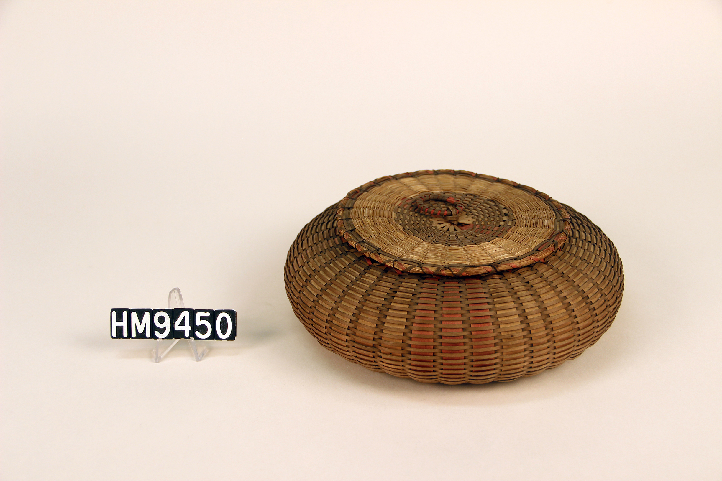 Image of a short, rounded basket with a cover and in the form of a squat sea urchin.