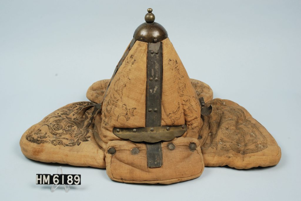 Image of helmet with flaps to cover ears. Cotton and metal elements.