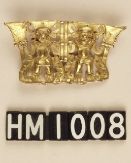 Image of ornament made of gold with two small figures wearing headdresses.