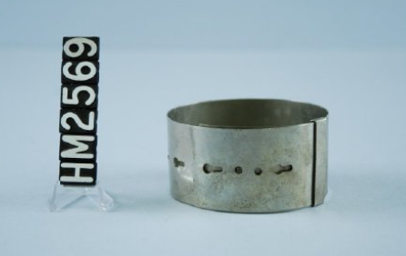 Image of a simple silver bracelet made of a wide band with holes allowing it to be different sizes.
