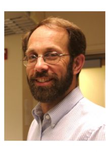 Image of Caucasian man with glasses and dark beard wearing collared shirt.