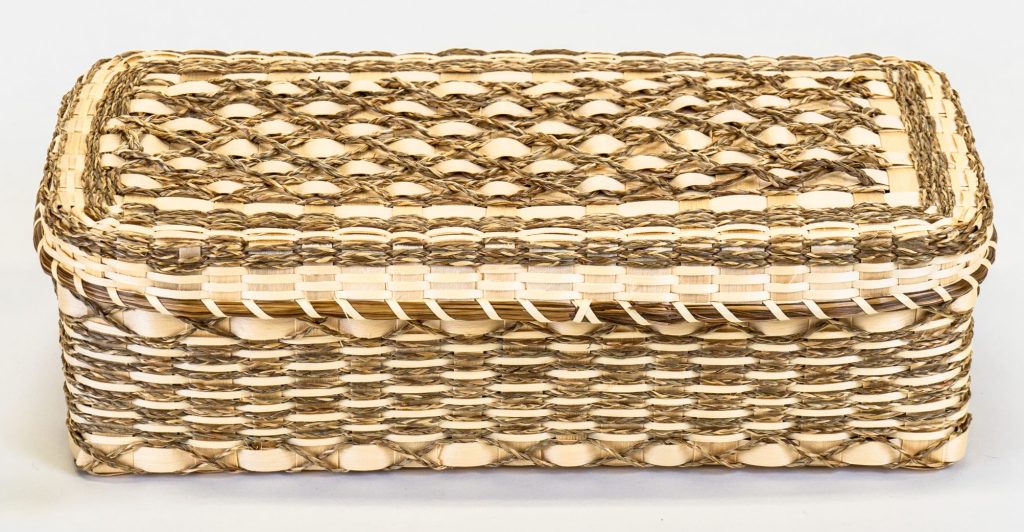 Rectangular basket with decorative motifs of braided grass.