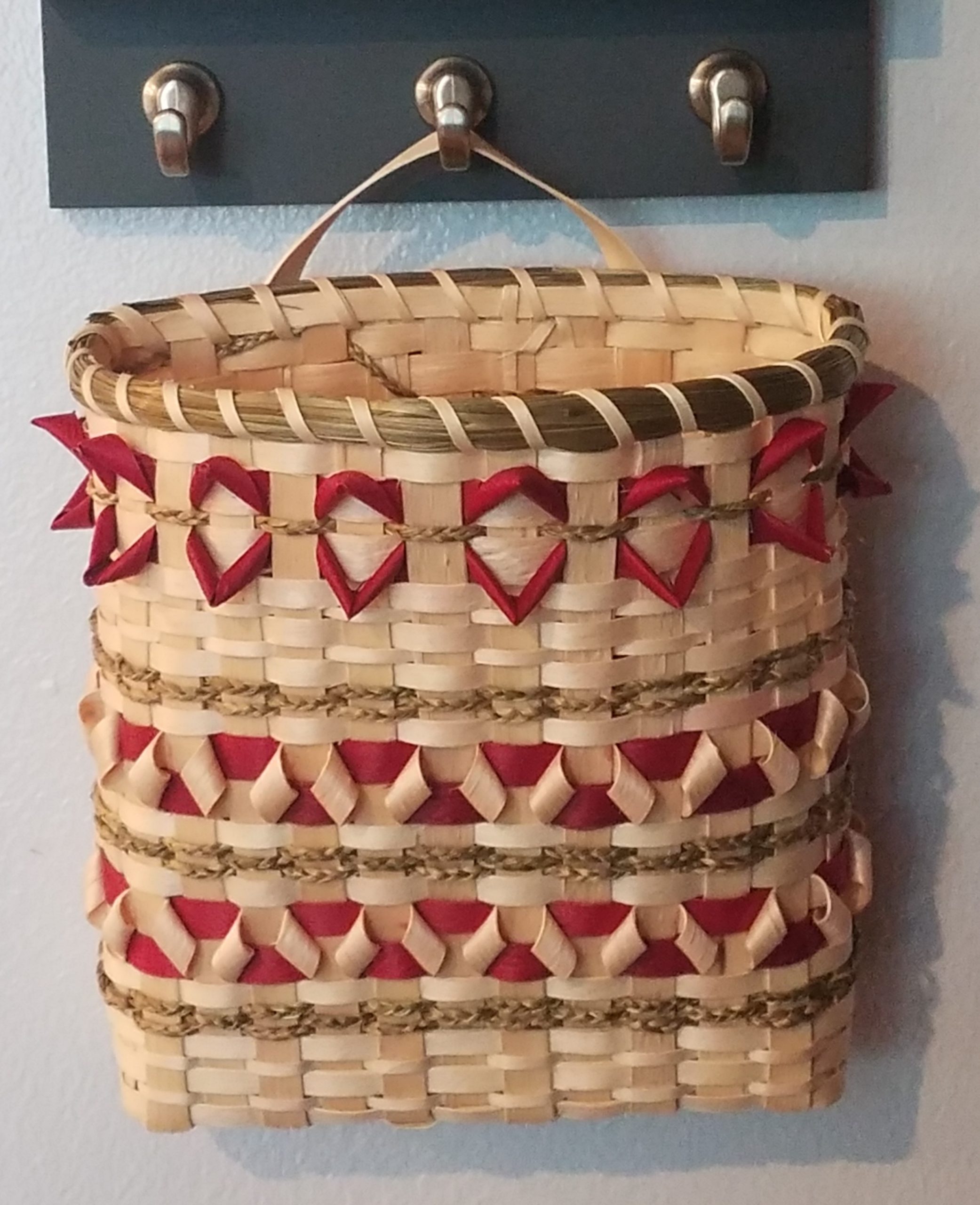 Basket hanging on wall. Red details.