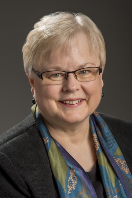 Image of Caucasian woman with short hair and glasses smiling at camera.