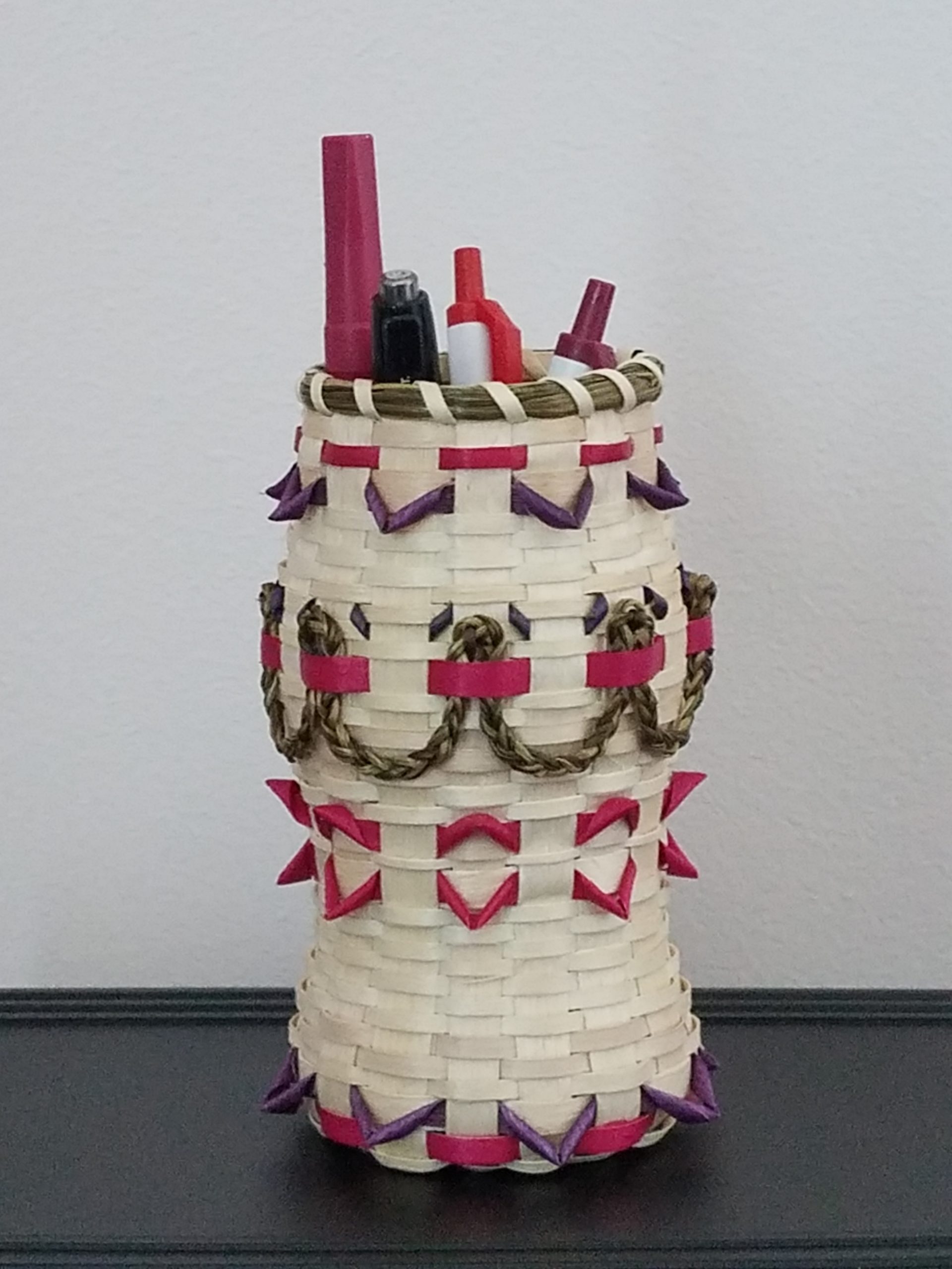 Basket holding pens and pencils. Details in red and sweetgrass.