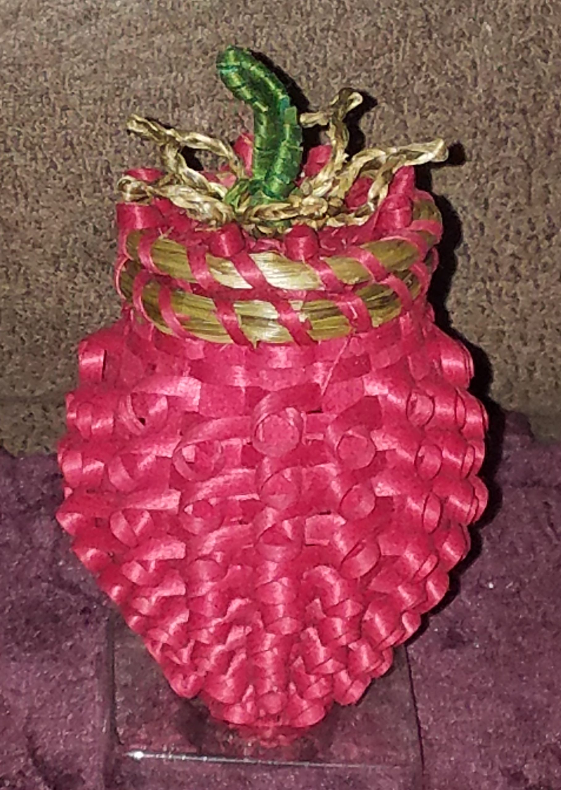 Basket shaped like a strawberry with red curls.