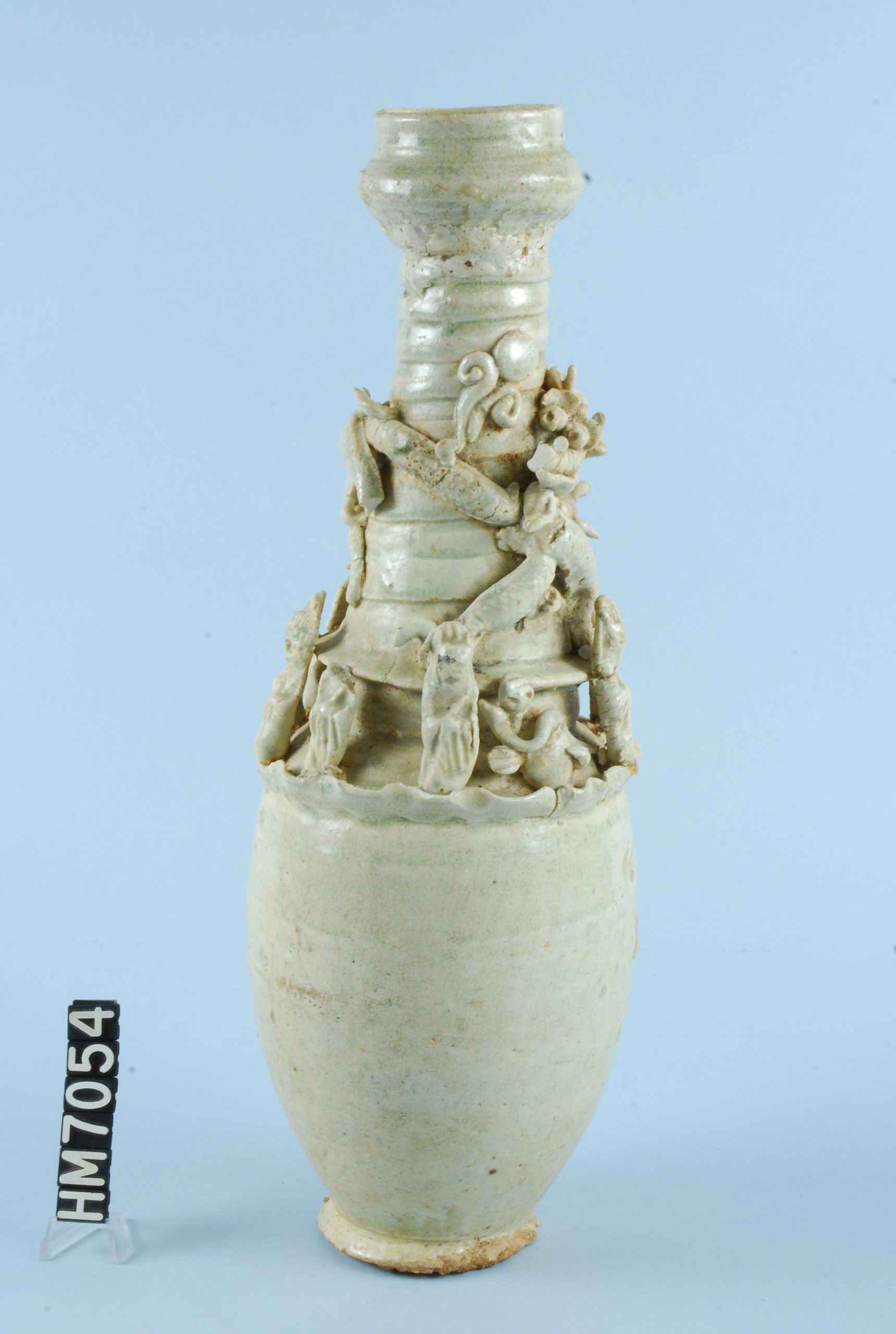Image of vase with small applied elements of people, animals, and spirits.