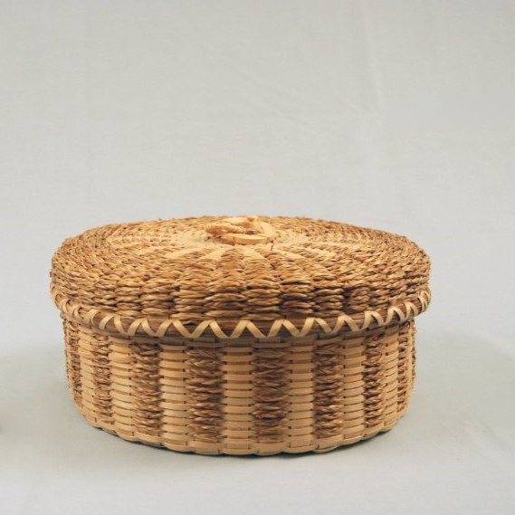 Small round basket with braided sweetgrass details.