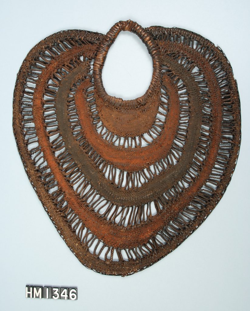 Image of a leaf-shaped object of woven fiber with portions painted orange.