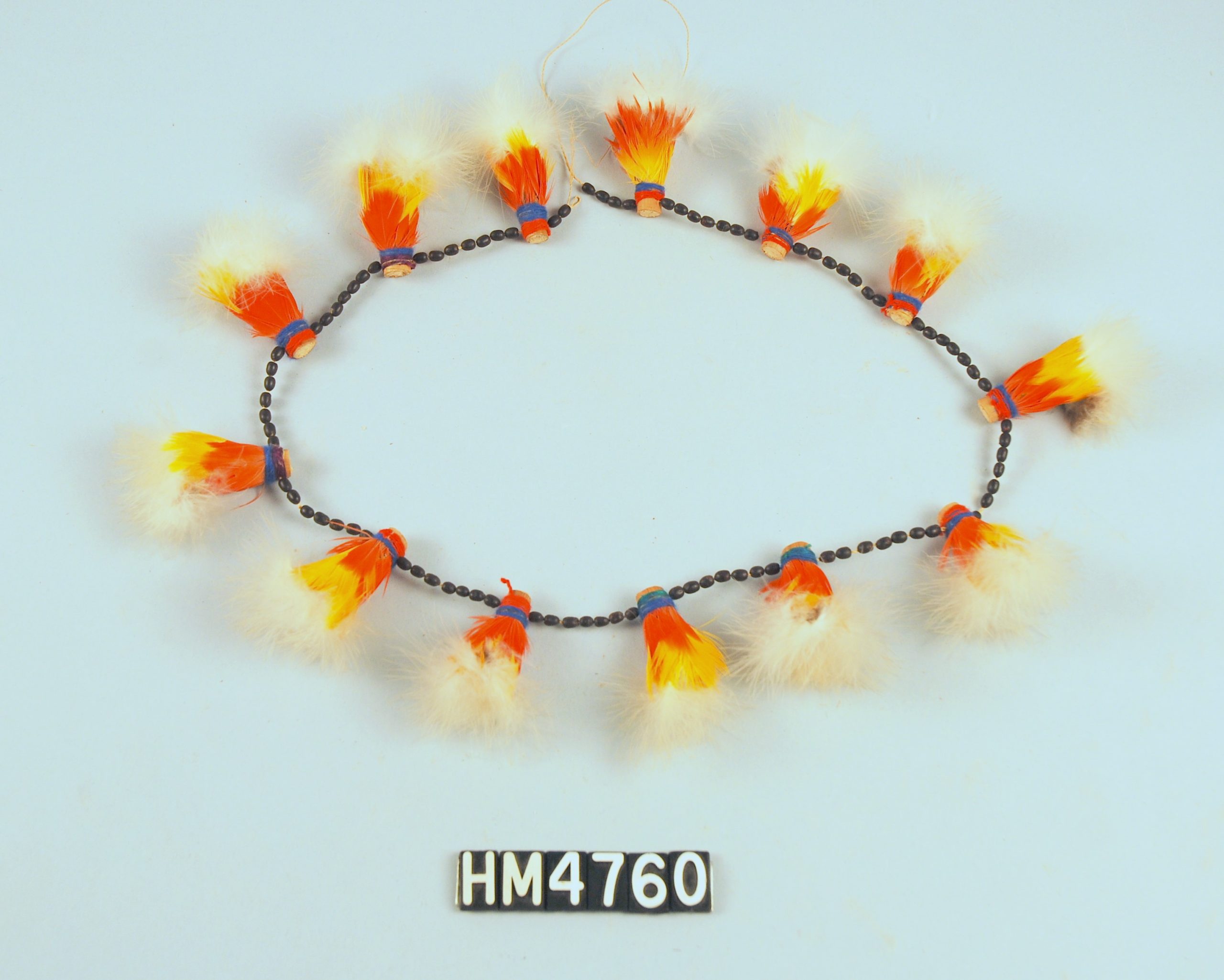 Image of a circlet made with tufts of feathers in white, yellow, and orange.