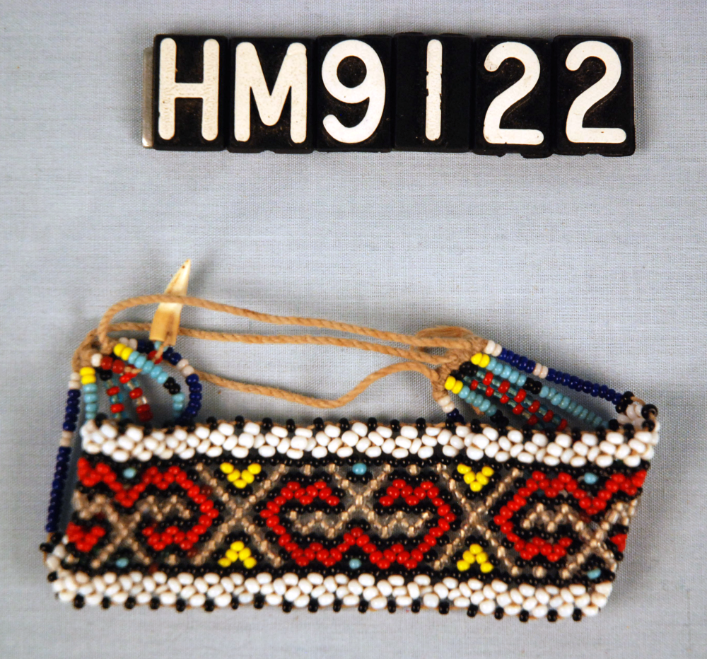 Image of a wide beaded bracelet with black, white, red, yellow, and gold beads.