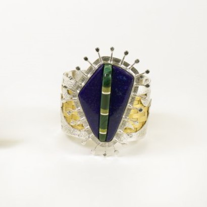 Image of a cuff bracelet with polished stone, silver, and woven wood elements.