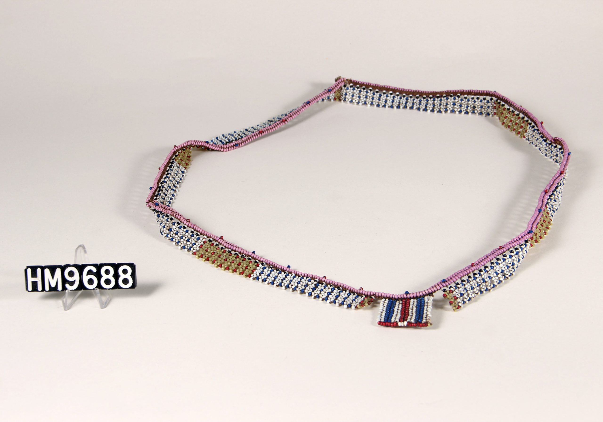 Beaded waist ornament in white, blue, pink, red, and yellow.