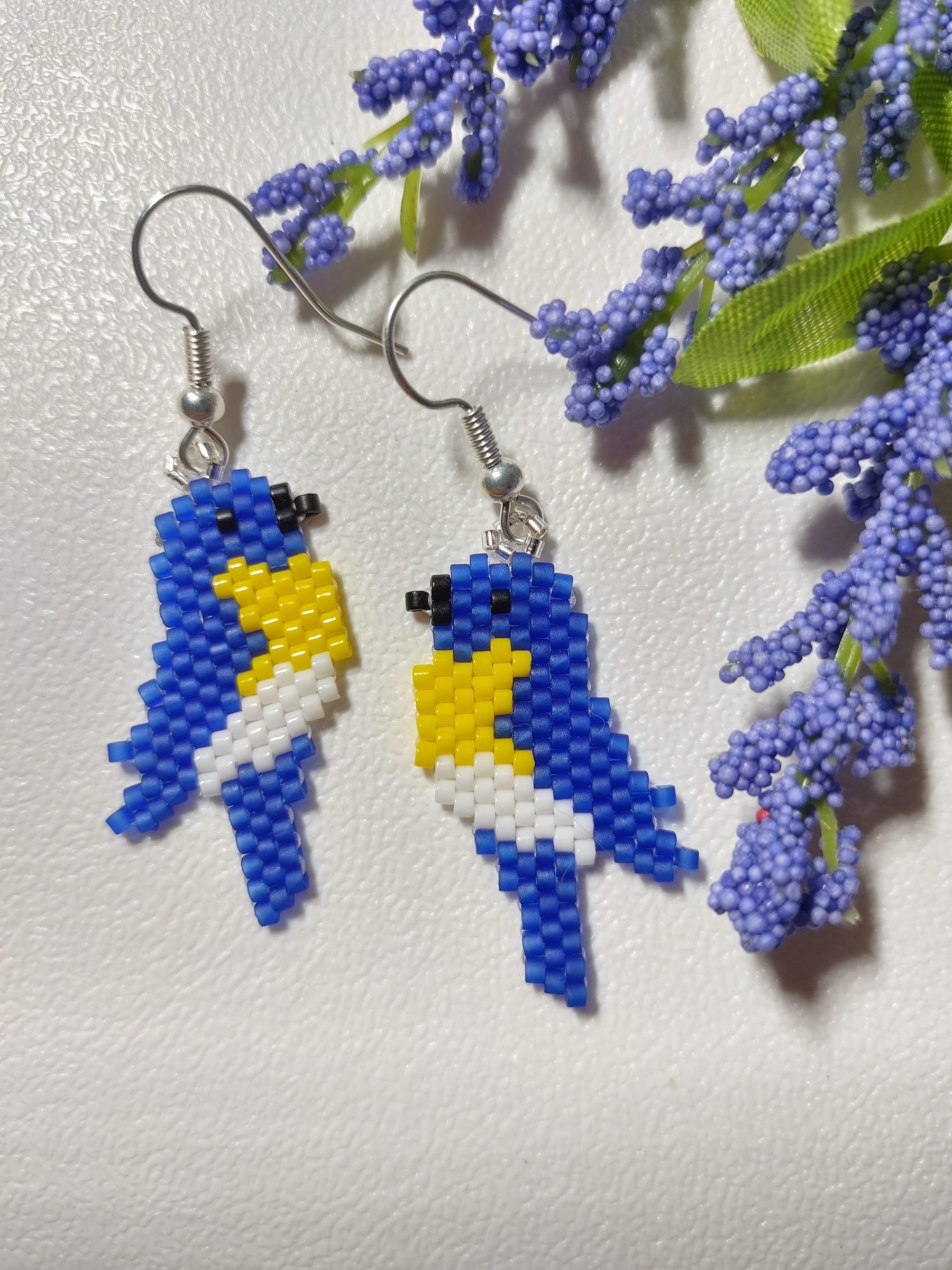 Image of dainty beaded earrings in the form of bluebirds.