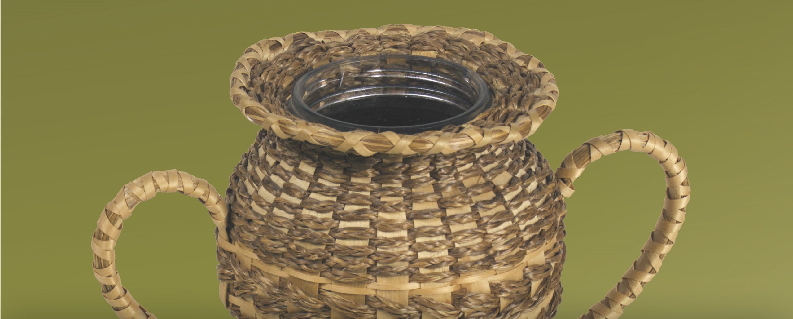 Detail image of a basket woven around a vase and with handles like a trophy.