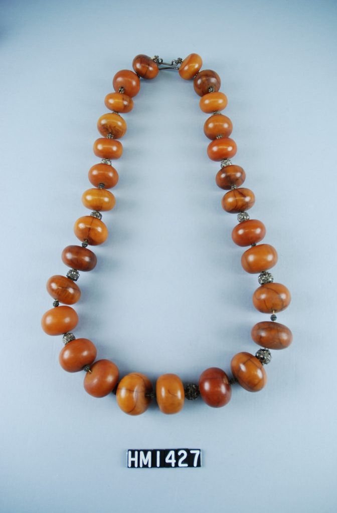 Image of necklace made with large, round, amber-colored beads.
